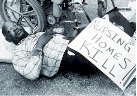 In this black and white photograph, 
      a man is lying on his back beside his wheel chair. Select this for more description of the image.